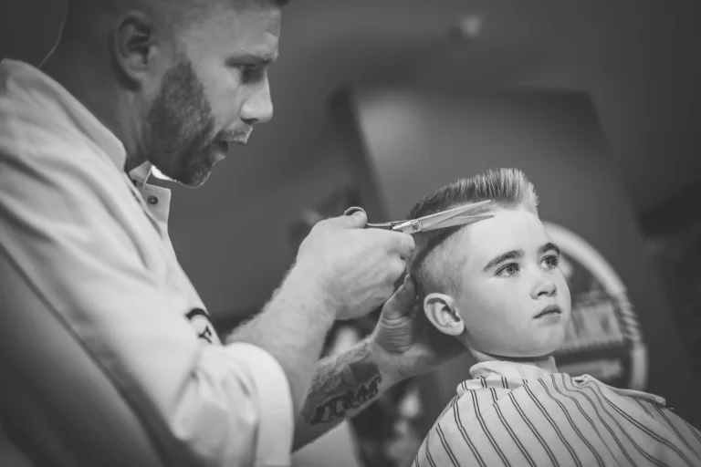 little-boy-visiting-hairstylist-in-barber-shop-2021-08-26-16-21-09-utc-modified-min